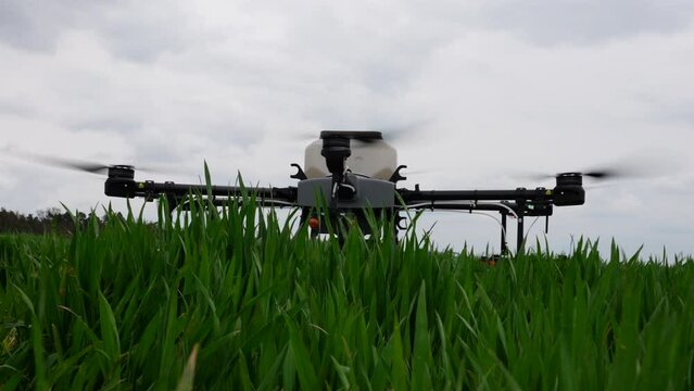 Agriculture Drone With Tank Landing in Green Farming Field, Close Up