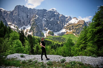 Naklejka na ściany i meble Mature woman standing at the edge of a cliff in Italian Alps