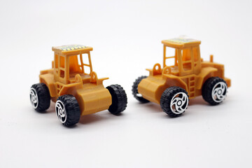 Fototapeta premium Two clean yellow toy trucks