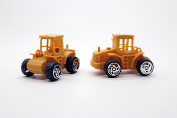 Fototapeta premium Two clean yellow toy trucks
