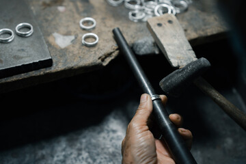 Close-up of craftsman hand making ring made of silver Folk handicrafts of Nan Province, Thailand	