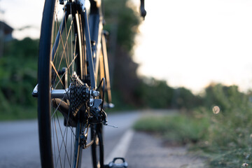 Road bike parked on a beautiful road sunset, warm light with copy space. 