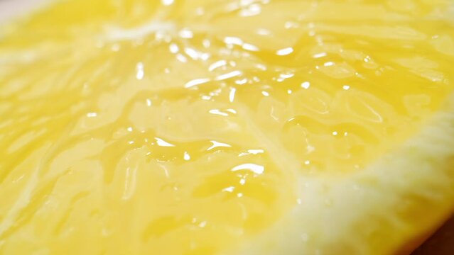 In a macro video, the lemon's textured peel becomes a landscape of bumps and pores, while its translucent segments hold a vibrant spectrum of citric acid-filled cells. Fruit and vegetable concept. 4K
