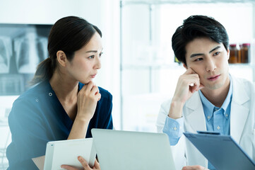 Doctors having a meeting while looking at electronic tablets and materials