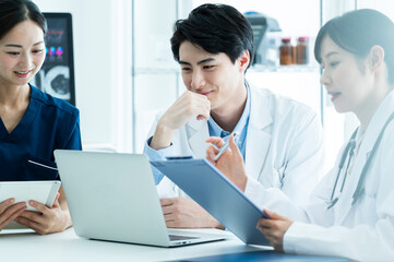 Obraz premium Doctors having a meeting while looking at electronic tablets and materials