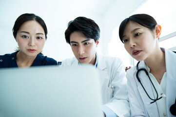 Doctors having a meeting while looking at electronic tablets and materials