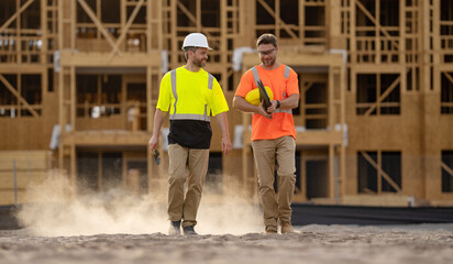 cheerful architect men with construction project. architect men discussing construction project