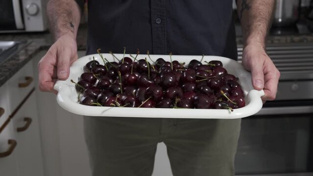 person showing seasonal fruit from home, tray with cherries, healthy, eco and healthy fruit with vitamins
