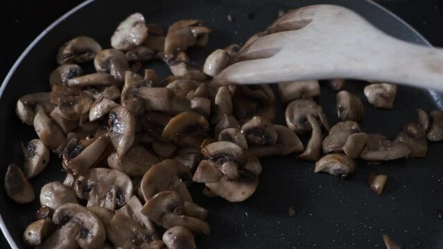 Stir the mushrooms cut into pieces in the pan with a wooden fork
