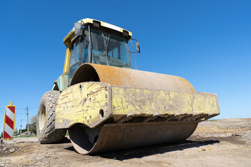 Soil Compactor, single drum road roller at the construction site of a highway.