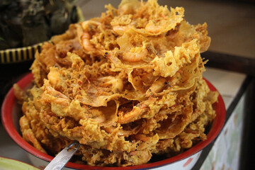 High angle view of a bunch of rempeyek udang, a deep-fried savoury Indonesian-Javanese cracker made from prawns and flour with other ingredients, bound or coated by crispy flour batter