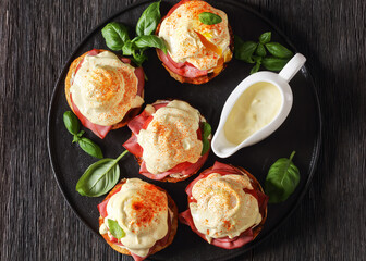 Eggs Benedict on black plate, top view
