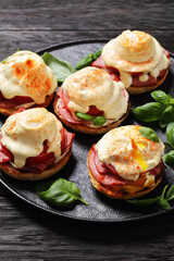 Eggs Benedict on black plate, top view