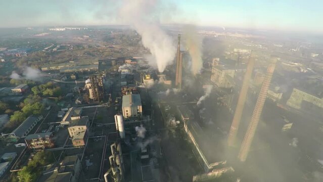 Dynamic aerial footage captures a chemicals production factory with smoke stacks, revealing the environmental impact of industrial pollution.