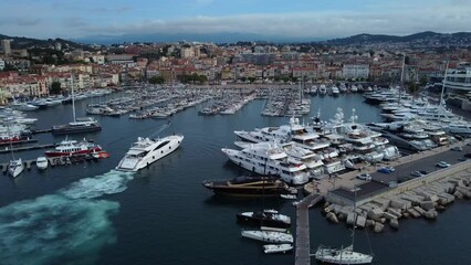 Drone shot following yacht arriving into port. Boat docking in marina