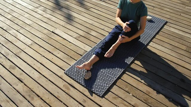 yoga woman practices on a wooden deck