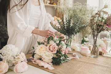 female hands florist makes a wedding bouquet in her shop. Floral design studio, making decorations and arrangements. Flower delivery, order creation. Small business. No face closeup