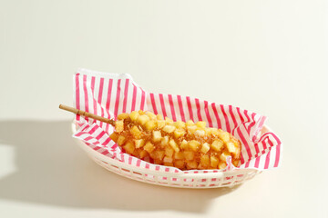 Delicious Crunchy Korean Style Chunky Potato Corn Dogs with Batter and Fried Potatoes. Isolated on Cream Background - obrazy, fototapety, plakaty