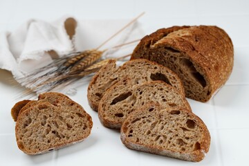 Traditional Spelled Sourdough Bread Cut into Slices on a White Wooden Background