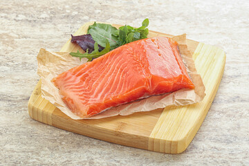 Raw salmon fillet over board