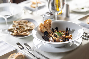Fish soup with seafood served in an esthetic way on a plate in a restaurant