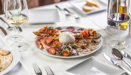 Italian antipasti appetizer for more people, with various types of food all on one plate