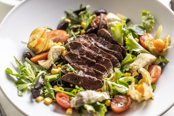 Protein and vegetable in a form of steak and mixed salad in a bowl