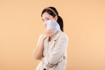 portrait of happy successful confident young asian business woman wearing white jacket holding cash...