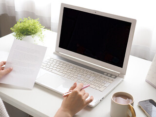 窓辺のデスクでラップトップを使用する女性、明るいワークスペース、パソコンで仕事をする女性の手元 - obrazy, fototapety, plakaty