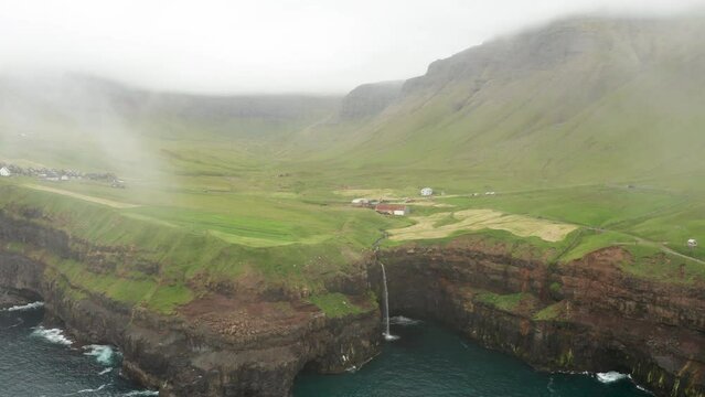 Sunset view of Mulafossur Waterfall and Gasadalur village. Vagar, Faroe Islands.