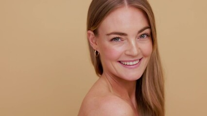 Close-up beauty portrait of young blonde-haired woman who softly looking down at her shoulder, and looks at the camera and smiles | Soft skin and skincare concept - Powered by Adobe