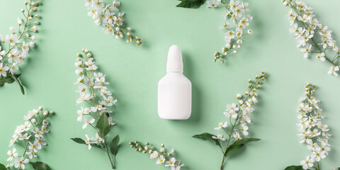 Seasonal spring allergies, fresh spring blooming branches tree and mock up white nasal spray bottle...