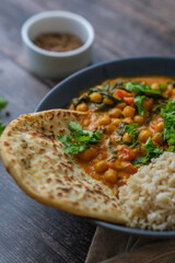 Vegan Chickpea curry on a dark background. Close-up. Healthy vegetarian food concept. Traditional Indian food concept.