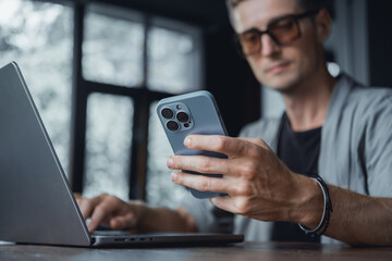 Young man using smartphone in hand, cafe, office,outdoor portrait business man, hipster style, internet, smartphone, office, Bali Indonesia, holding, mac OS, manager, freelancer, concept