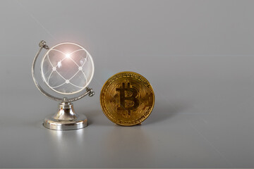 World globe with bitcoin isolated on a grey background.Bitcoin and cryptocurrency investing concept.