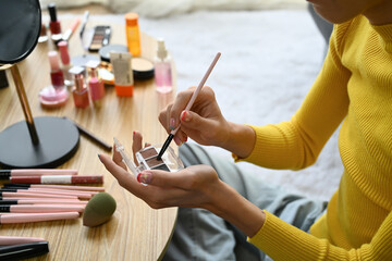 Smiling Asian gay man blogger filming daily makeup routine tutorial on smartphone. LGBTQ, domestic...