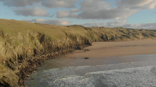 The stunning aerial shot of Perran Sands during sunset, large cliffs surround the coastline