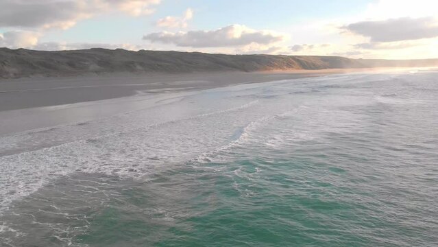 The stunning aerial shot of Perran Sands during sunset, the waves are calm and there's a serene vibe in the air