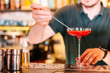 man hand bartender making cocktail in glass on the bar counter