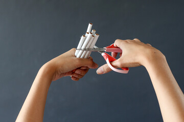 Hand crushing cigarette using scissor. Concept of quitting smoking, World No Tobacco Day.