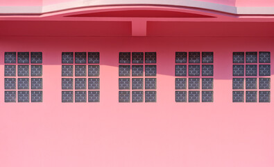 Row of Glass brick blocks under balcony on pink concrete wall of modern house building with sunlight and shadow on surface