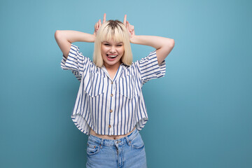 joyful blonde young female adult in blouse with grimace isolated background