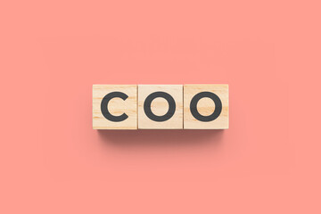 COO (Chief Operating Officer) wooden cubes on red background