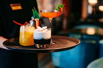 glasses alcohol cocktail set on a waiter tray in bar