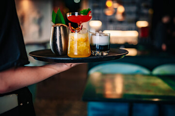 glasses alcohol cocktail set on a waiter tray in bar