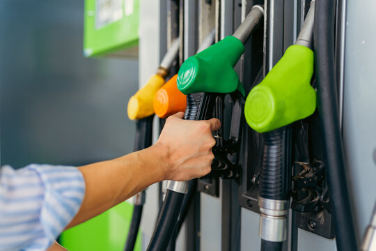 a close-up image of a woman's hands on fuel fuller at a gas station