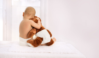 Baby hugging teddy bear