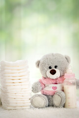 stack of diapers with soft teddy bear on table