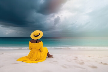 Obraz premium A woman sitting on the beach, wearing a beautiful hat and a pretty yellow dress, gazing at the horizon. Generative AI
