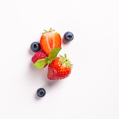 Obraz na płótnie Canvas Summer composition with assorted berries, strawberry, raspberry and blueberry on white background, top view, flat lay. Creative food concept with copy space
